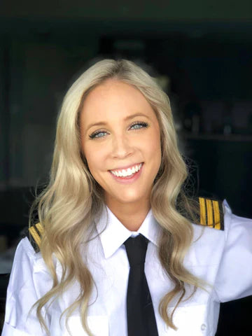 Kristy smiling at the camera wearing pilot attire