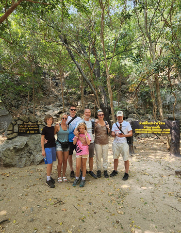 A family group photo in front of green trees