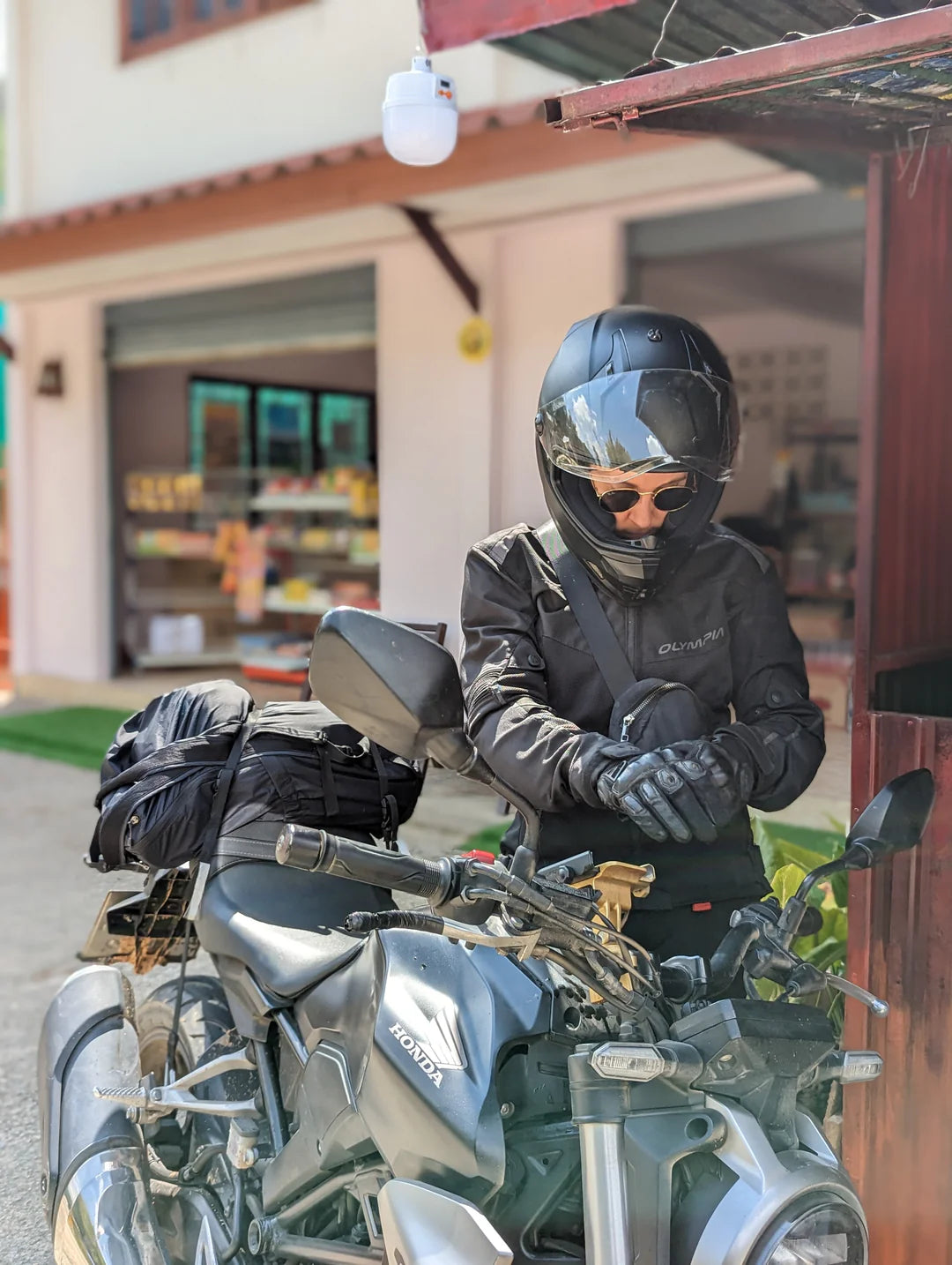 A person in full leather gear wearing a helmet next to a motorcycle