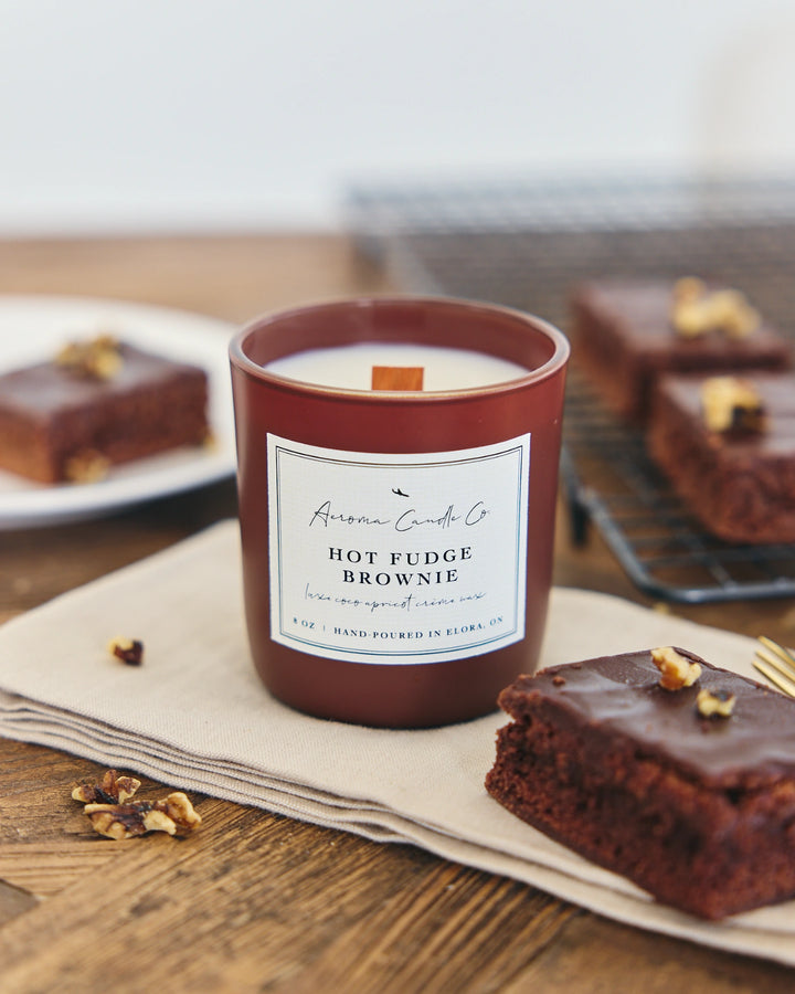 Hot fudge brownie candle with brownies on a wooden table