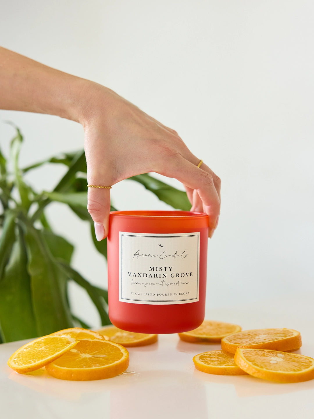 Hand holding a red candle labeled &