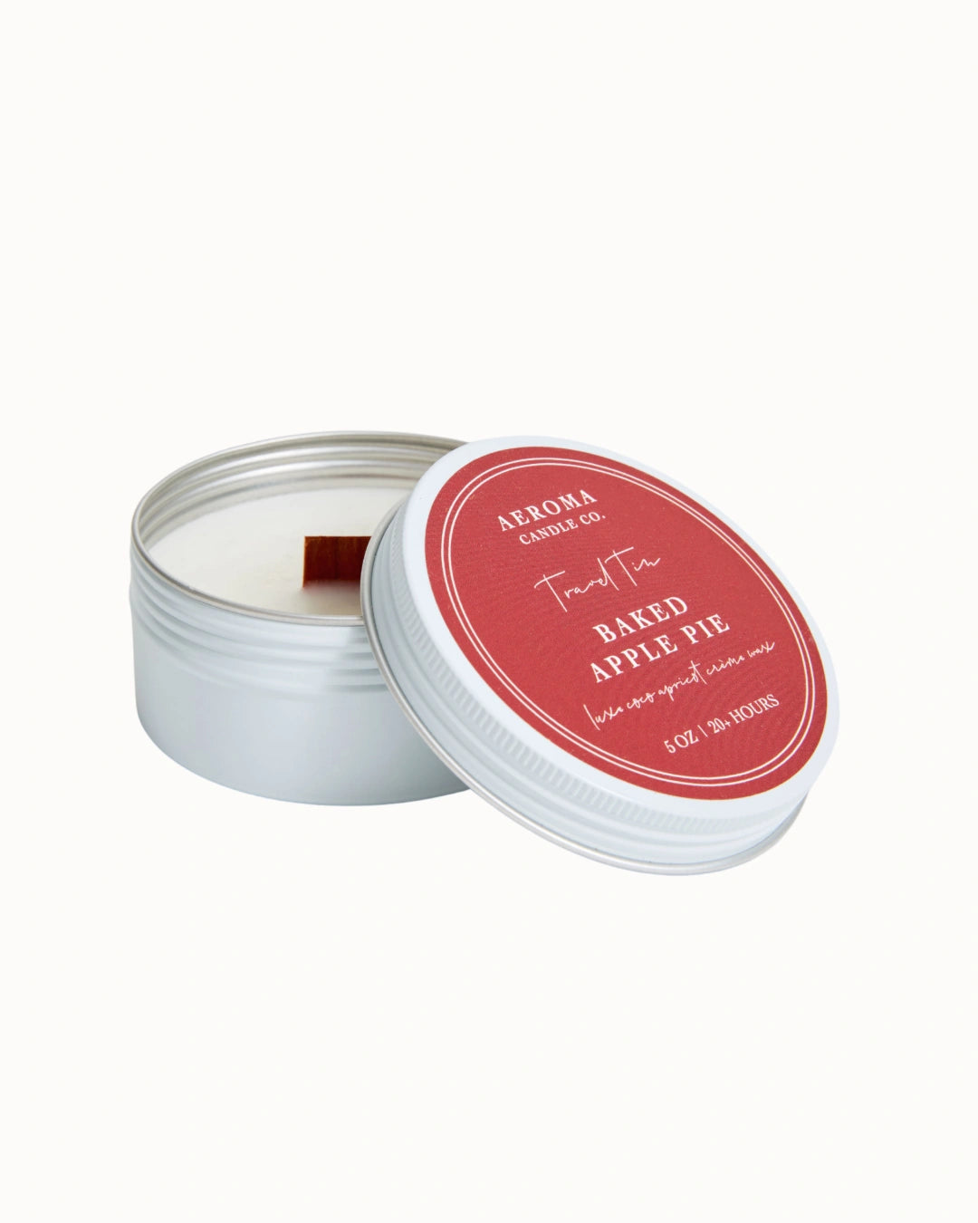 Candle in a tin with a red lid on a white background