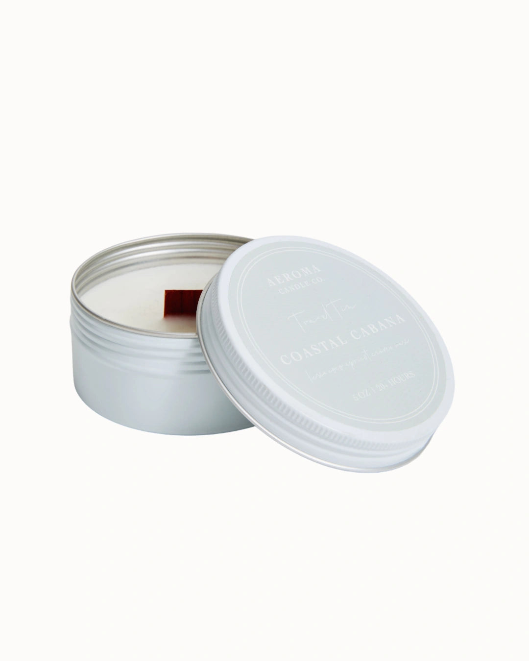 Candle in a metal tin with a white lid on a white background